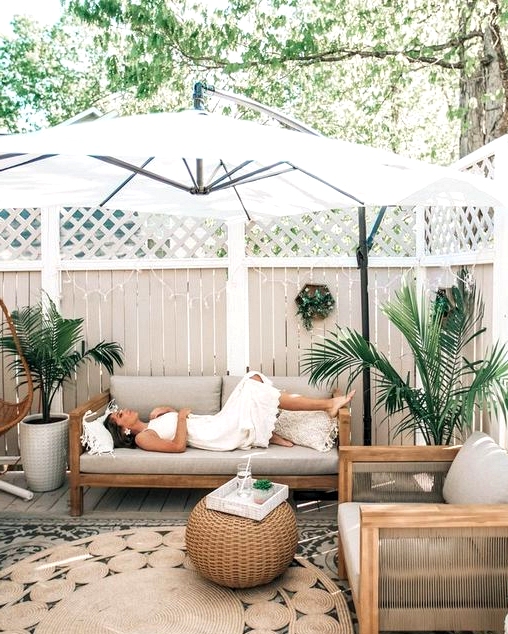 Relaxing backyard patio design with a large umbrella that provides much needed shade. 