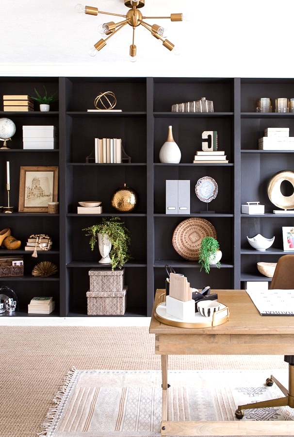 Black bookshelves create a feature wall in this modern home office. 