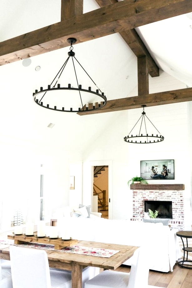 A farmhouse great room with a modern twist! Bold rustic beams and hoop lighting are the showstoppers of this farmhouse living room. 