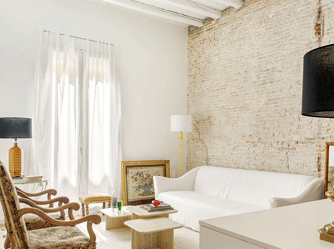 White studio apartment with brick wall and antique armchairs in Barcelona (60 sqm)