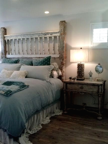 a shabby chic bedroom with a shabby whitewashed bed, blue bedding, whitewashed nightstands, a driftwood table lamp and built-in lights