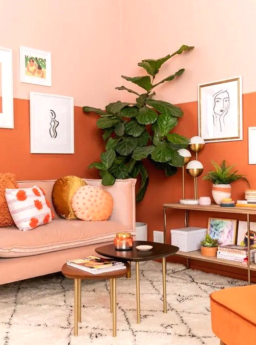 a gorgeous warm-toned living room with color block walls, a blush sofa and an orange chair plus cool artworks