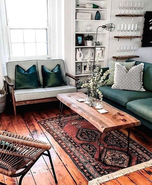 a mid-century modern sitting room with a light and dark green loveseat, a living edge table, a woven chair, a printed rug and built-in shelves