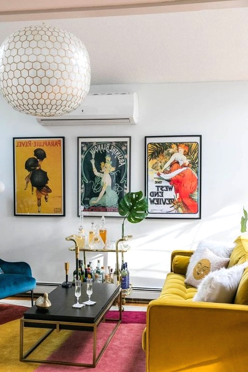 a vibrant living room with a bold rug, a mustard sofa and a navy chair, a chic coffee table and a bar cart plus a bold gallery wall
