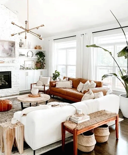 a welcoming mid-century modern living room with a built-in fireplace, a white and rust-colored sofa, a woven bench, potted plants