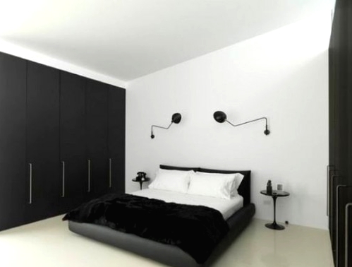 a contrasting bedroom with a couple of sleek black wardrobes that are used for storage and that help to declutter the space