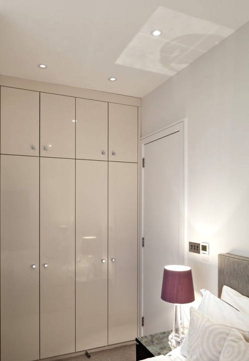a small and sleek grey wardrobe built into an awkward nook is a cool idea for a modern bedroom and a nice way to make use of this awkward space