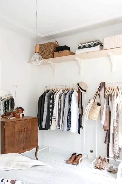 a makeshift closet in a serene bedroom takes one wall and there's much storage space