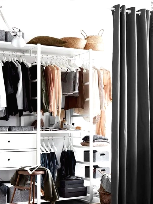 a closet in the bedroom is separated with a large curtain from the rest of the bedroom