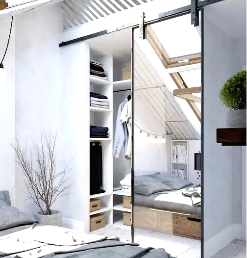 a Scandinavian bedroom with an attic closet, which is separated with a mirror barn door from the rest of the space