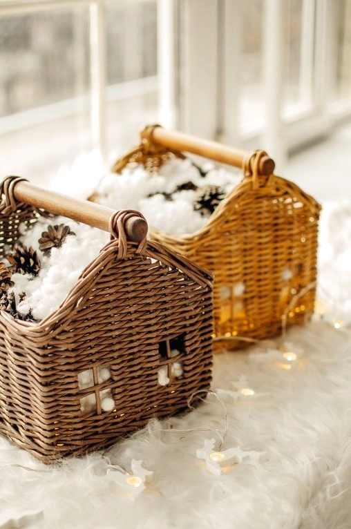 pretty house-inspired baskets with faux snow and pinecones plus lights are a great idea for a rustic space at Christmas
