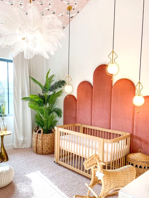 a mid-century modern nursery with coral upholstery on the wall, a stained crib, baskets, a pink ceiling, layered rugs and greenery