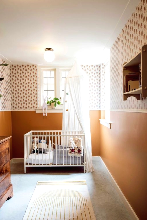 a welcoming mid-century modern nursery with printed wallpaper and rust walls, a vintage stained dresser, a white crib, neutral textiles, an open shelf