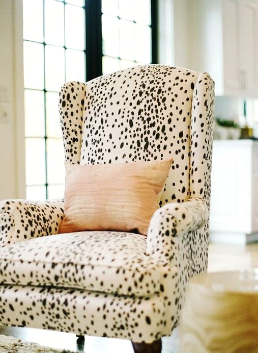 a Dolmatin printed chair with a peachy pillow is a catchy and stylish accent to the space, it's a bold and pretty idea