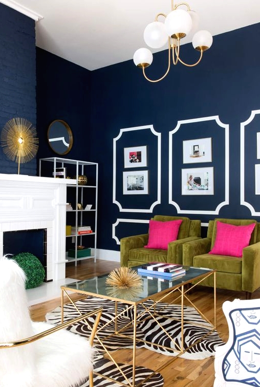 a refined living room with navy walls, a faux fireplace, green chairs with hot pillows, zebra print rugs, a glass coffee table and chairs