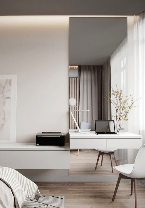 a minimalist neutral bedroom with a floating desk and a mirror, a floating storage unit, a bed with neutral bedding
