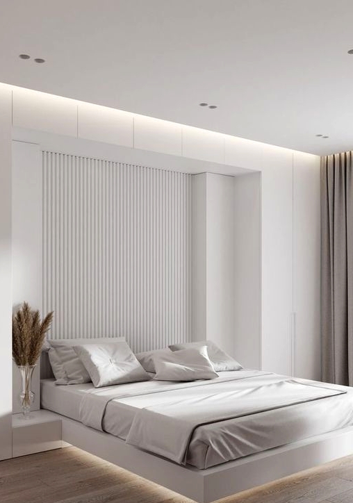 a minimalist neutral bedroom with a slab accent wall, a floating bed with lights, built-in nightstands and greige curtains