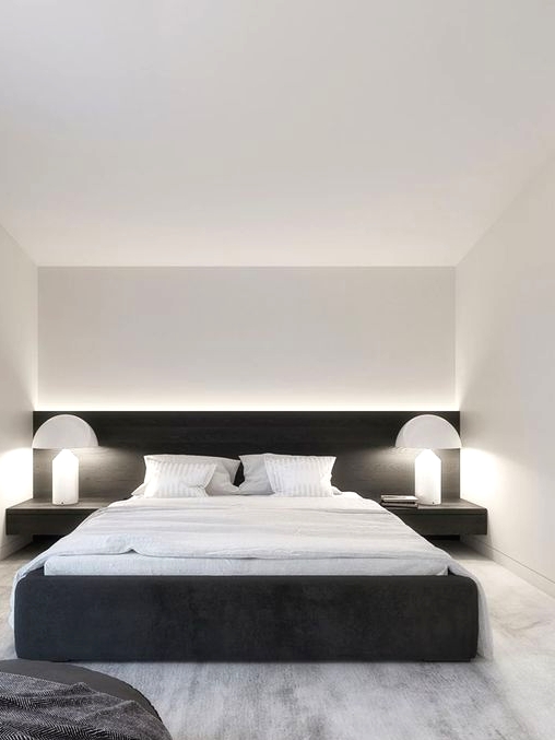 an ultra-minimal and contrasting bedroom with a black upholstered bed and black nightstands, white table lamps and white bedding