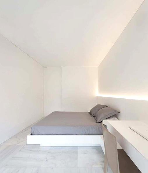 an ultra-minimalist white bedroom with a bed, built-in lights, a built-in desk and a plywood chair is cool