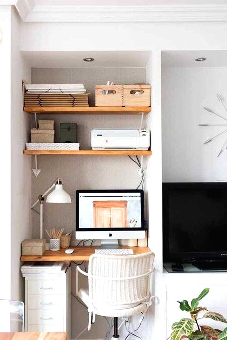 a tiny awkward nook space taken by a built-in working space - a desk, some shelves and a white office chair plus a white table lamp