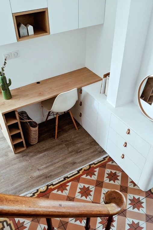 an awkward nook taken by a home office, with a built-in desk, a built-in sleek storage unit and white sideboards