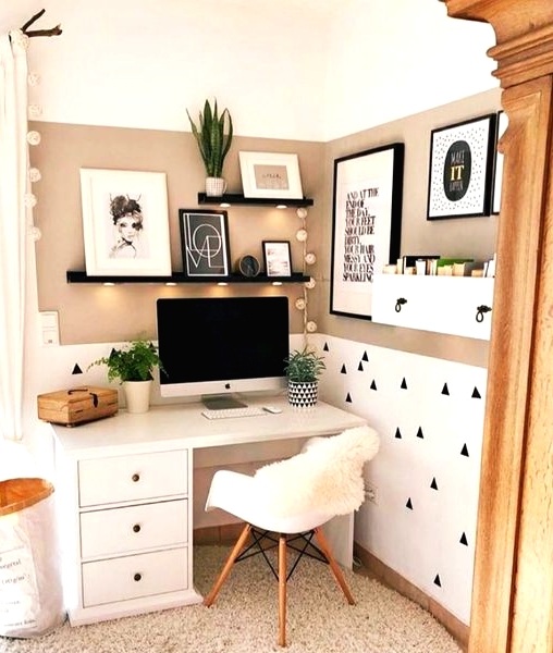 a small and cozy awkward nook with tan walls and a geometric print, a white desk and a chair, black shelves with lights and some potted plants