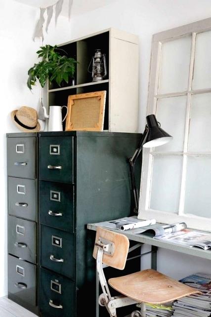 a vintage industrial home offie, a metal desk, a metal and wood chair, a metal paper cabinet and some greenery