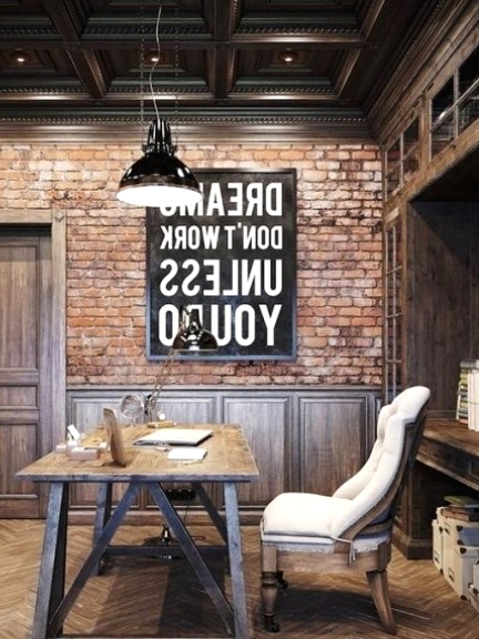a vintage meets industrial home office with brick walls, paneling, a wooden desk and vintage chairs plus metal pendant lamps
