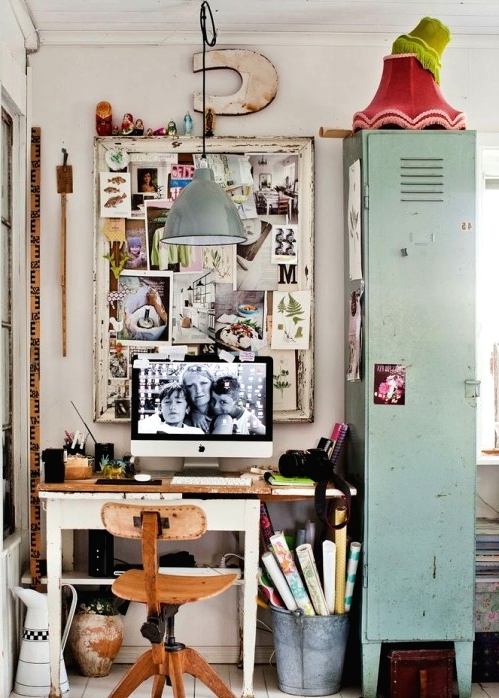 an industrial home office nook with a white desk, a small chair, a mood board, a light green storage cabinet of metal, a pendant lamp and various decor