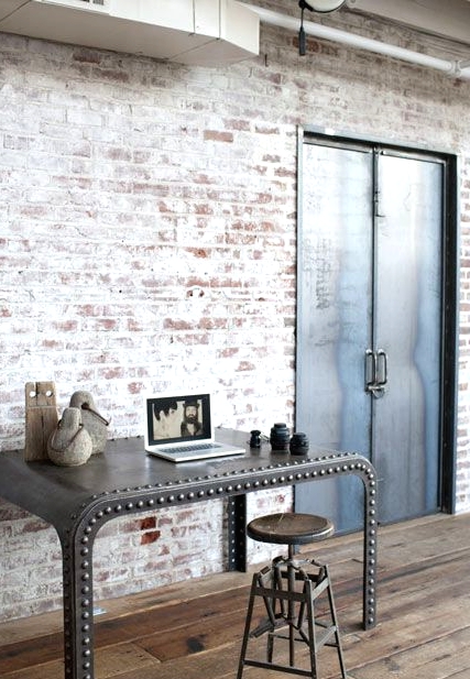 a catchy industrial home office space with whitewashed brick walls, a catchy metal desk, a metal stool and some wabi-sabi decor