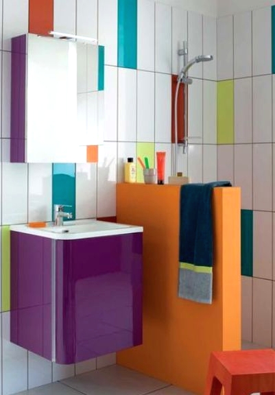 a modern colorful bathroom done with white, neon yellow, orange, teal and turquoise skinny tiles and with a bright half wall and vanity is wow