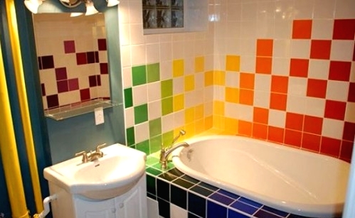 a white bathroom with a navy accent wall and with super bright tiles for an accent is a creative idea for a kid's space