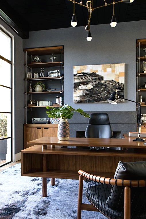 a refined modern home office with built-in storage units, a stained desk with two tabletops, black leather chairs