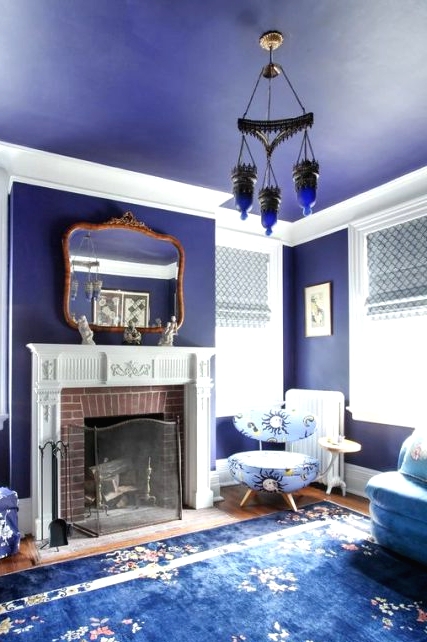 a fabulous very peri vintage living room with a fireplace and a vintage mantel, a catchy pendant amp and blue and purple floral print furniture
