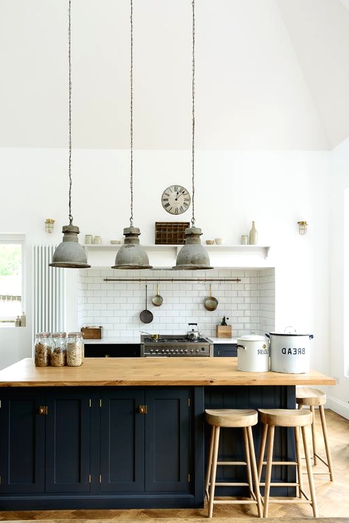 a chic traditional kitchen with black shaker style cabinets, a large kitchen island with storage and a seating zone around the corner