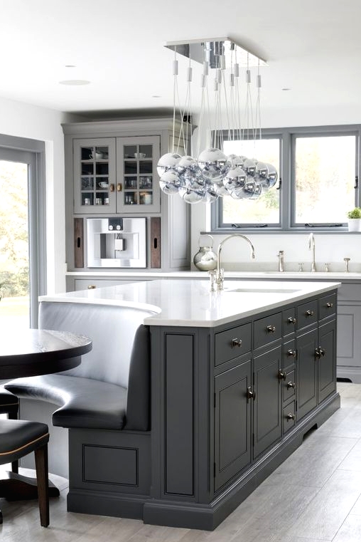 a modern graphite grey kitchen with a large kitchen island that shows off a banquette seating integrated right in it