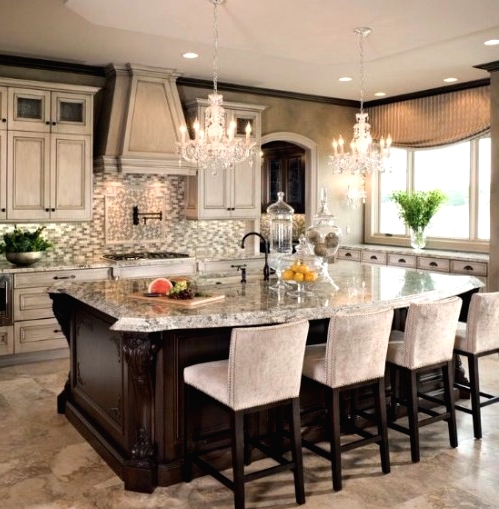 a chic vintage kitchen with neutral cabinets, a whitewashed hood, crystal chandeliers, a dark stained kitchen island with an eating space and tall stools