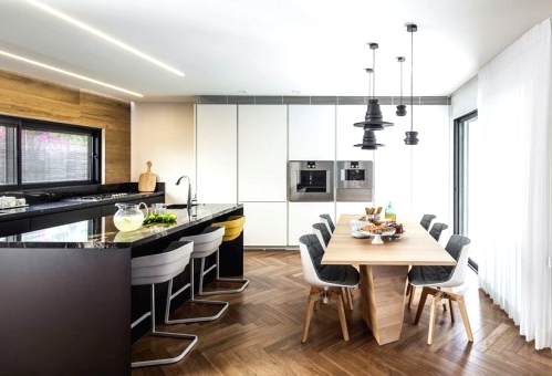 a contemporary black kitchen with sleek cabinets, a large black kitchen island with modern stools to have bites here