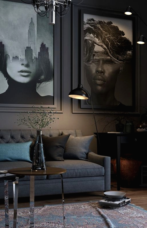 a slate grey living room with a slate grey sofa, oversized artworks, a black console table and a floor lamp, a printed rug