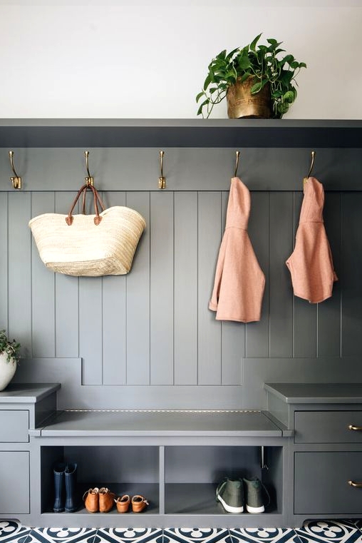 a slate grey mudroom unit with drawers, open storage units, hooks and a shelf is a stylish idea