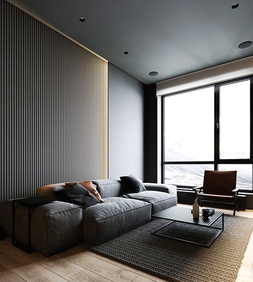 a slate grey wooden slab accent wall, a grey sofa with black pillows, a concrete ceiling, a rug and a black coffee table