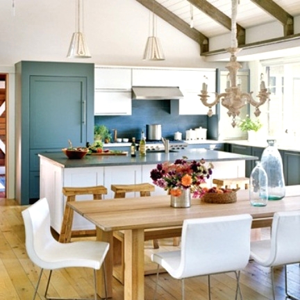 a welcoming barn kitchen with wooden beams on the ceiling, stone blue cabinets and a white kitchen island. a stylish modern farmhouse dining space with a wooden table