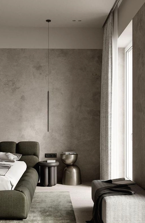 a contemporary bedroom with grey limewashed walls, a green upholstered bed, catchy nightstands and an upholstered bench
