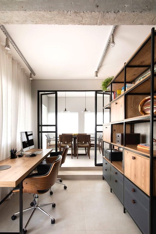 a contemporary industrial home office with a large storage unit of wood and metal, a stylish shared desk and leather and plywood chairs