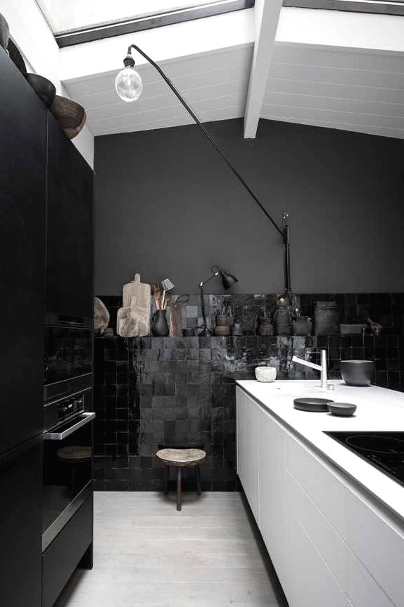 a fantastic kitchen with matte black walls, a gorgeous black zellige tile wall, a white kitchen island and black cabinetry
