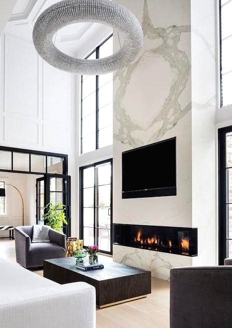 a luxurious living room with a large marble slab with a built-in fireplace and a TV is the centerpiece of the room