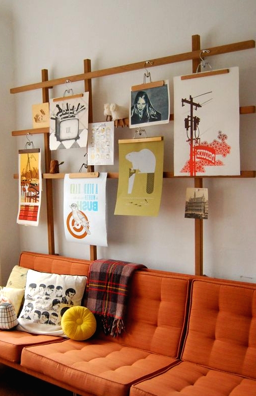 a plywood stand with lots of artworks hanging is a very creative idea, you may also hang some pots and planters here