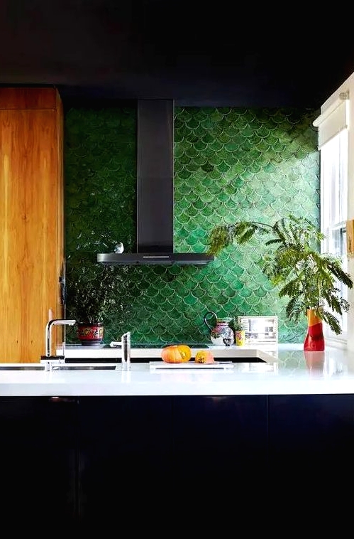 a masculine inspired kitchen accented with forest green fish scale tile and white countertops for a contrast