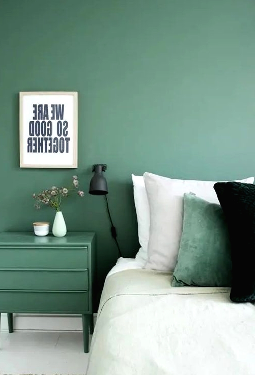 a muted green wall and a matching nightstand plus a matching pillow for relaxation and comfort