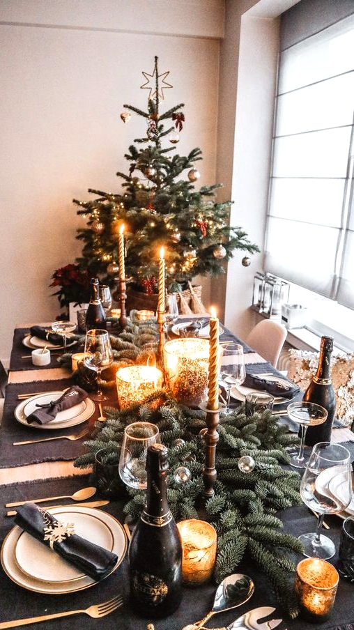 a fabulous Christmas tablescape with graphite grey placemats, an evergreen runner, mercury glass candleholders, chic gold cutlery